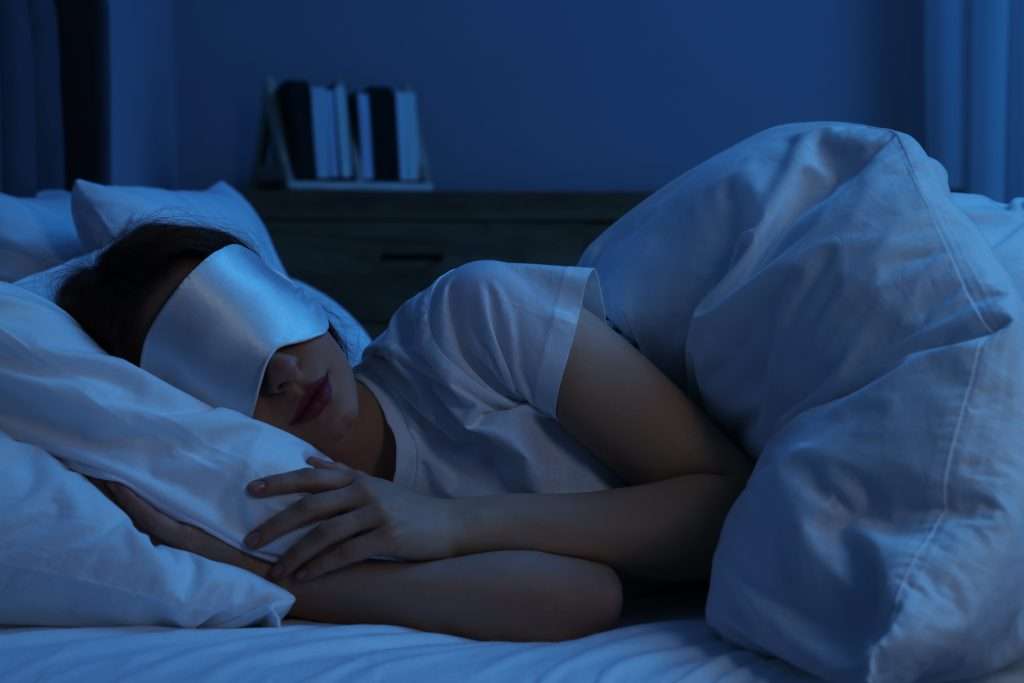 vrouw slaapt in een donkere slaapkamer