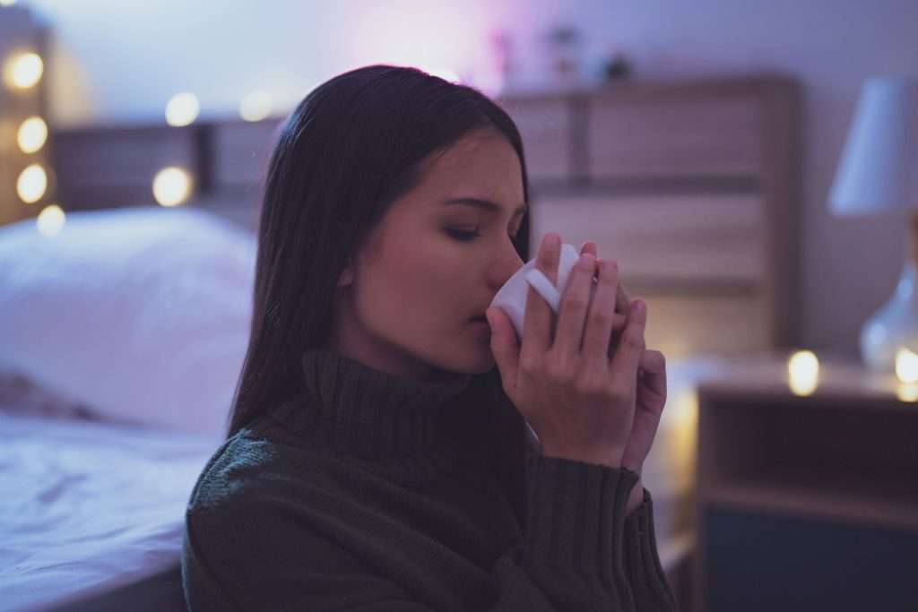 vrouw drinkt thee voor het slapengaan