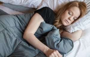 vrouw ligt onder verzwaringsdeken te slapen