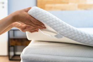 woman holding mattress topper