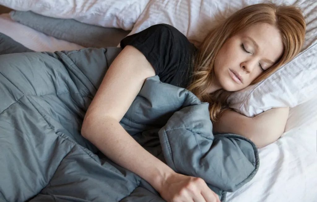 women is sleeping under a weighted blanket